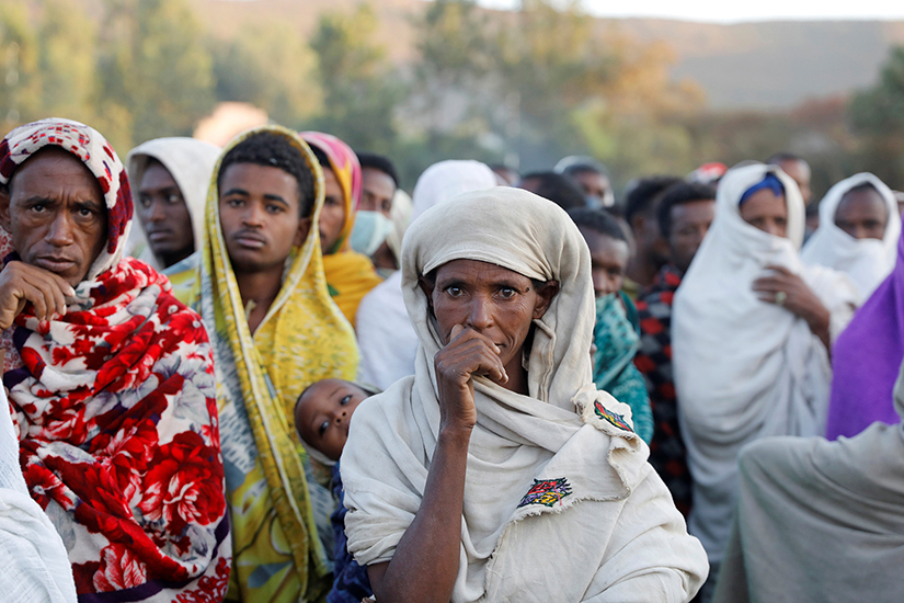 People displaced by fighting in Ethiopia’s Tigray region waited in line to receive food donations at a temporary shelter in the town of Shire March 15, 2021. The war has displaced more than 1 million people. Photo Credit: Baz Ratner | Reuters