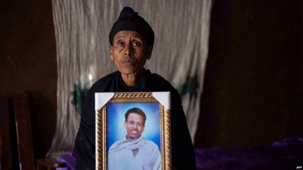 Likitu Merdasa holds a portrait of her son Desta Garuma, a 27-year-old rickshaw driver, allegedly killed by security forces, at her home in Nekemte, West Oromia, Ethiopia, Feb. 26, 2020.